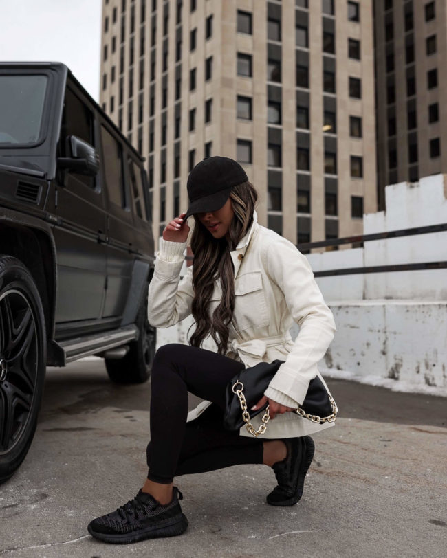 fashion blogger mia mia mine wearing a white utility jacket and black leggings from walmart