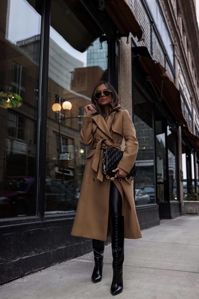 fashion blogger wearing a camel coat and lv black coussin bag