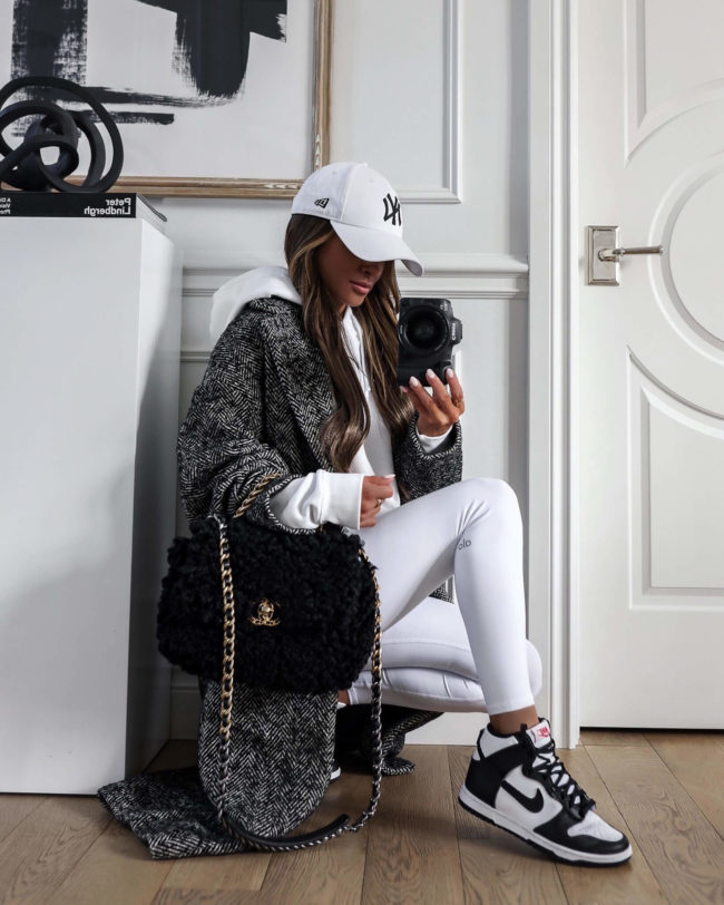 fashion blogger wearing white alo yoga leggings and nike dunk high sneakers