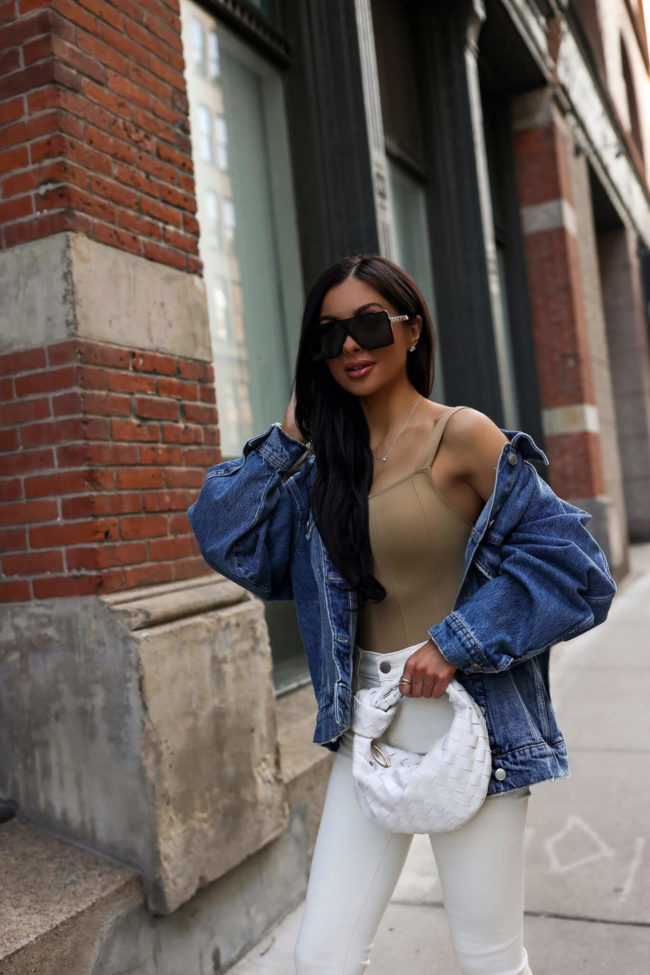 fashion blogger mia mia mine wearing a good american bodysuit with a denim jacket from bloomingdales