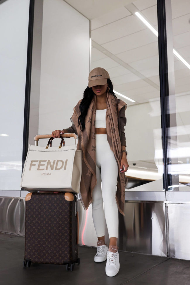 fashion blogger mia mia nine wearing churchs white sneakers to travel