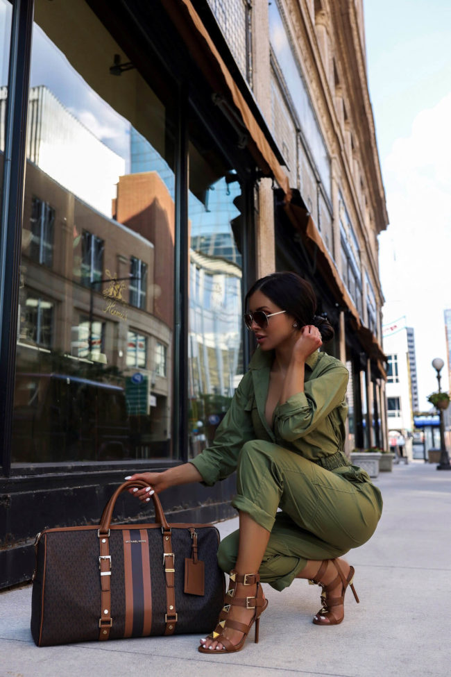 fashion blogger wearing a utility jumpsuit by michael kors