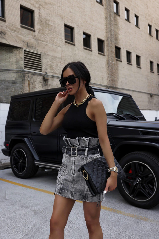 fashion blogger wearing a gray denim skirt and black tank top for summer