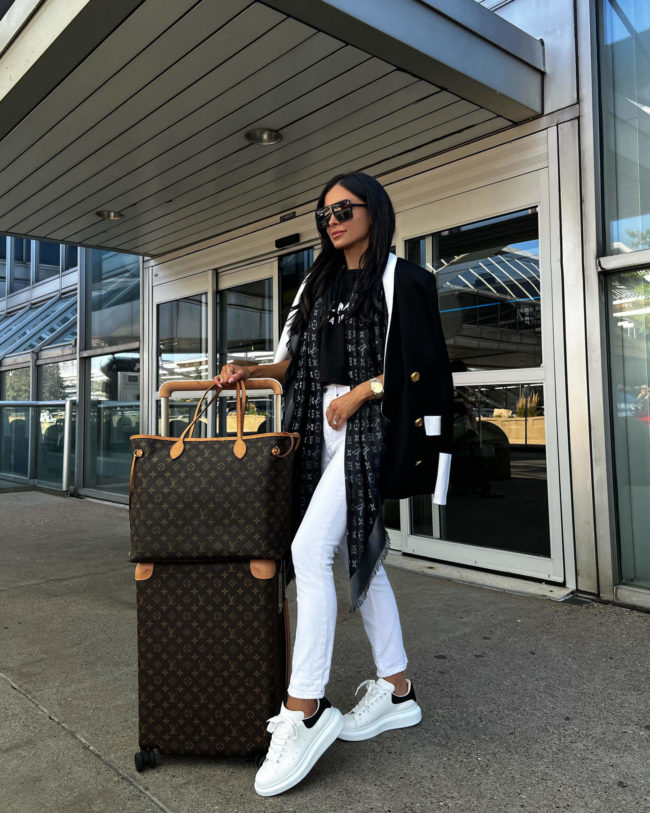 fashion blogger mia mia mine with louis vuitton luggage at the airport