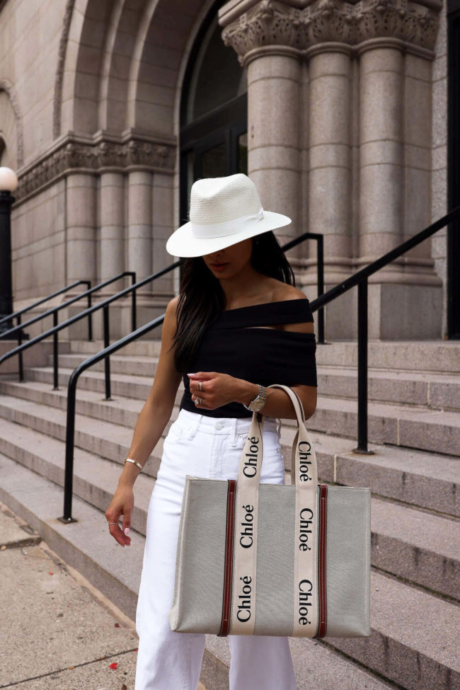 fashion blogger wearing a black bodysuit from saks and a white panama hat