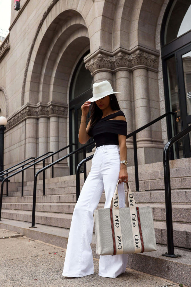 fashion blogger mia mia mine wearing a black bodysuit and white denim from saks