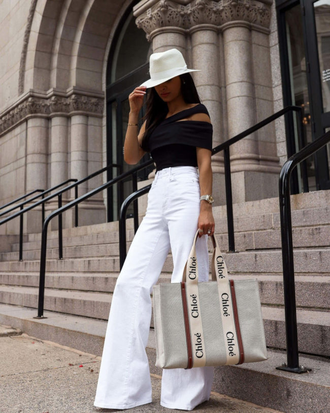 fashion blogger mia mia mine wearing a black bodysuit and white denim from saks