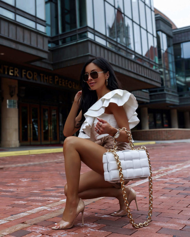 fashion blogger mia mia mine wearing a white ruffle top and leather shorts from karen millen