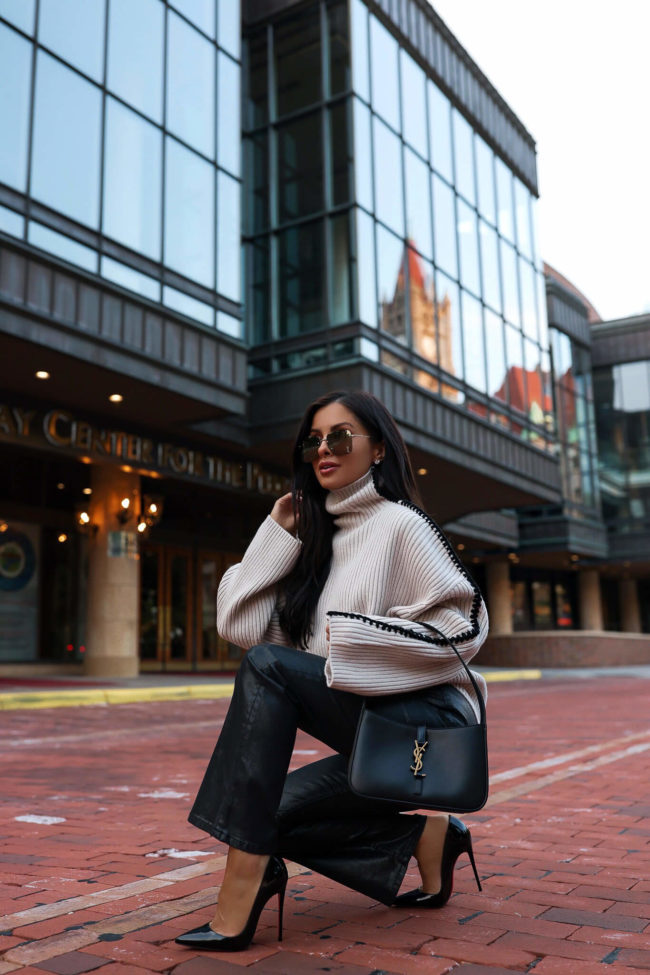 fashion blogger mia mia mine wearing coated denim pants and a chunky knit sweater from neiman marcus