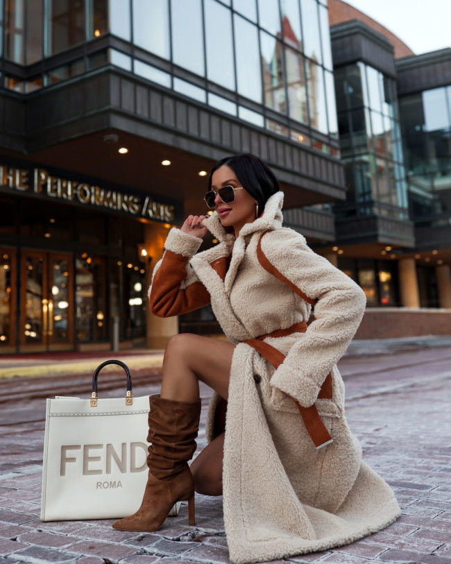 fashion blogger wearing a shearling coat and slouchy boots by karen millen
