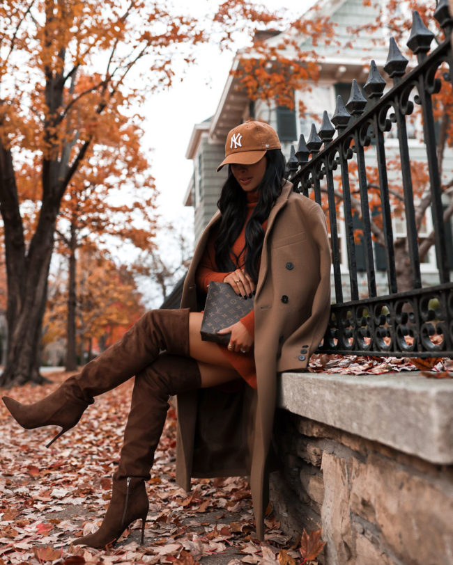fashion blogger wearing over the knee boots and a camel coat