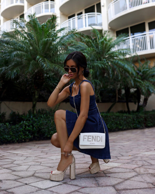 fashion blogger wearing a free people denim dress with platform heels