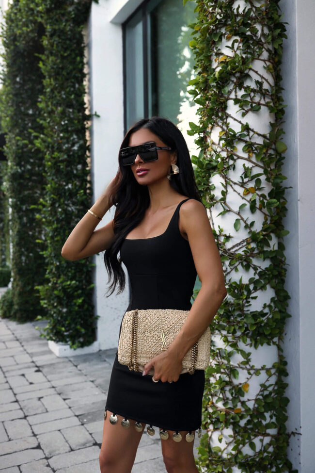 fashion blogger mia mia mine wearing a black mini dress from saks and a ysl raffia bag in palm beach florida