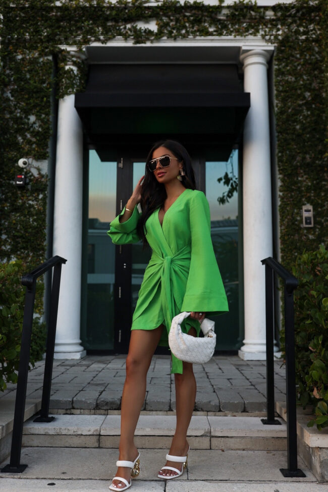 mia mia mine wearing a revolve green dress and sculptural heels