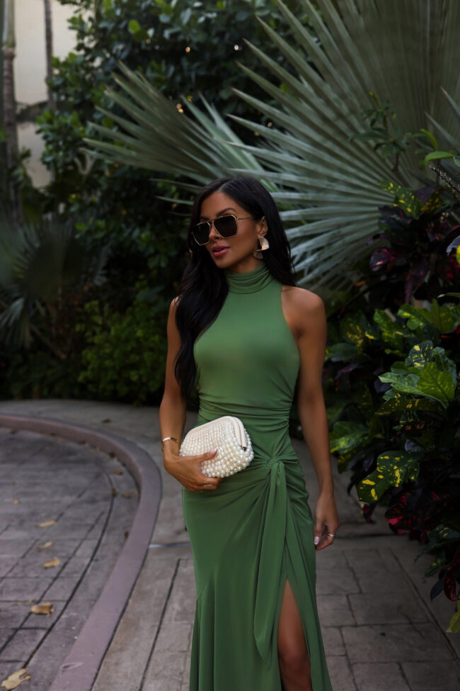 fashion blogger wearing a green dress and cult gaia clutch