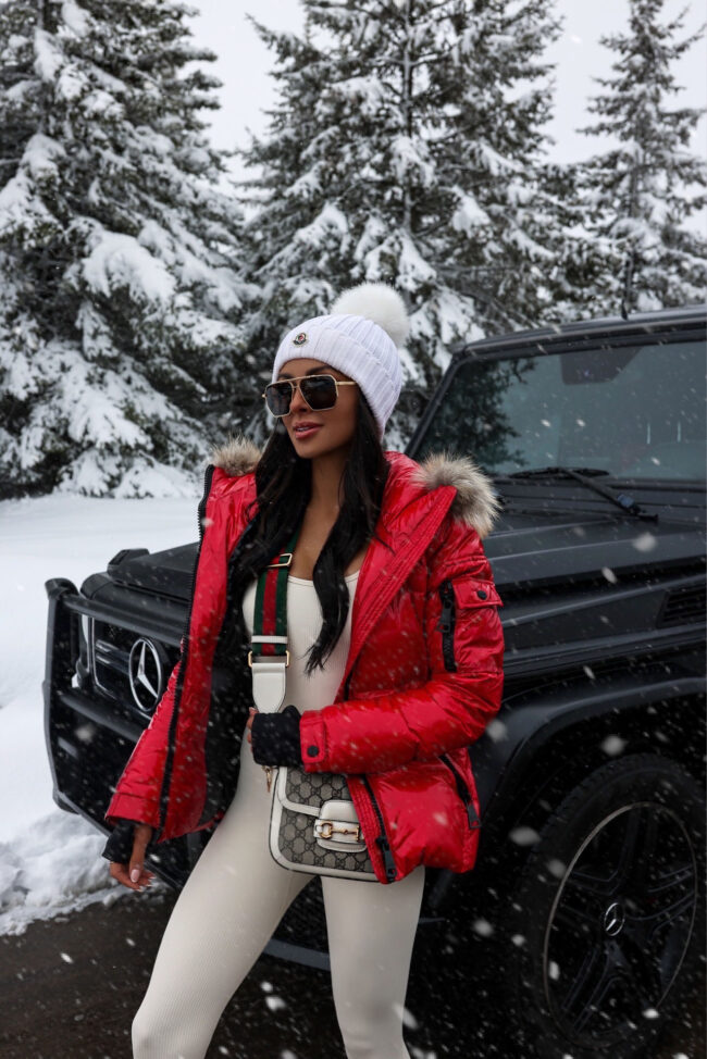 fashion blogger wearing a red puffer jacket and moncler beanie
