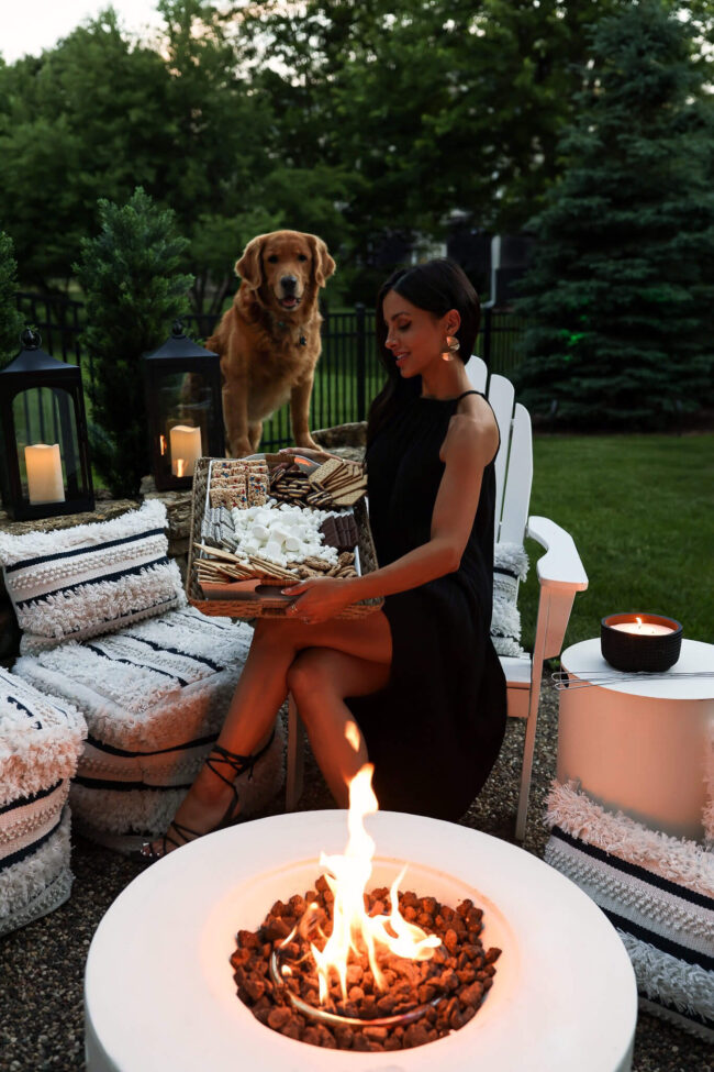 fashion blogger mia mia mine in her backyard fire pit with golden retriever