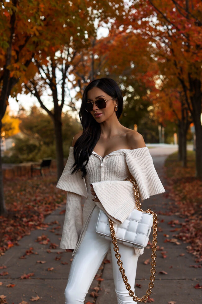 fashion blogger mia mia mine wearing an ivory off the shoulder sweater from revolve