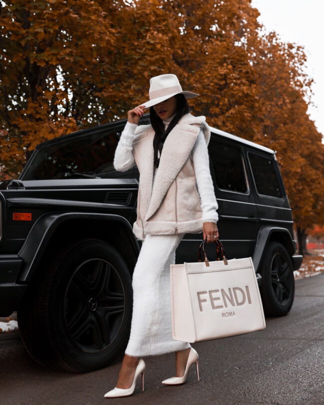 fashion blogger mia mia mine wearing a sherpa vest with a sweater dress from nordstrom