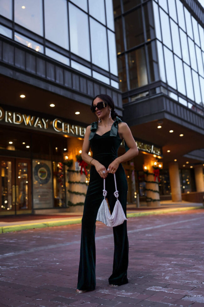 fashion blogger mia mia mine wearing a velvey jumpsuit with tie sleeves from nordstrom