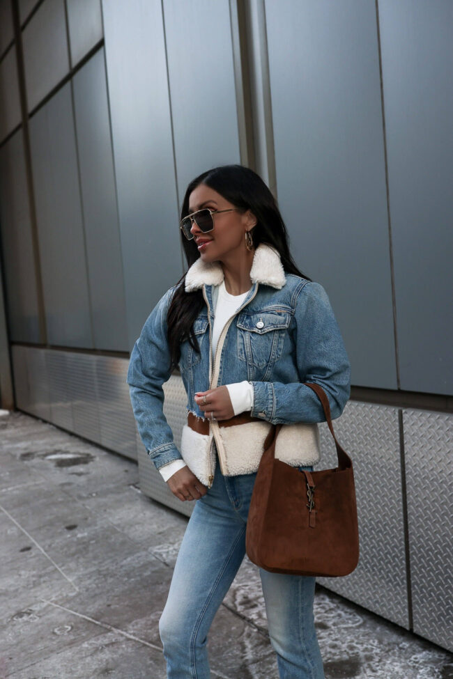 fashion blogger wearing a denim shearling jacket from saks