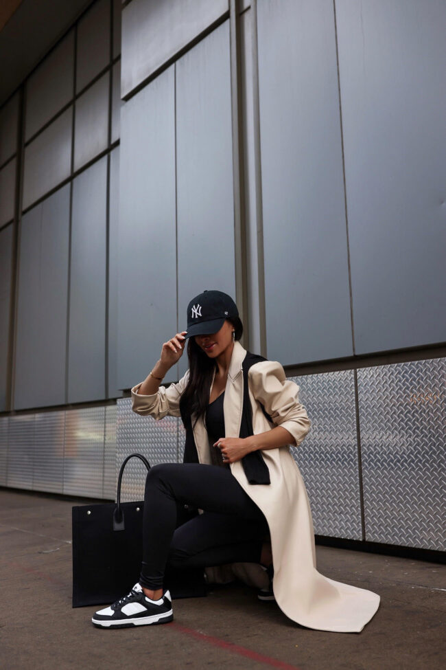 fashion blogger wearing black and white sneakers and a trench coat from walmart