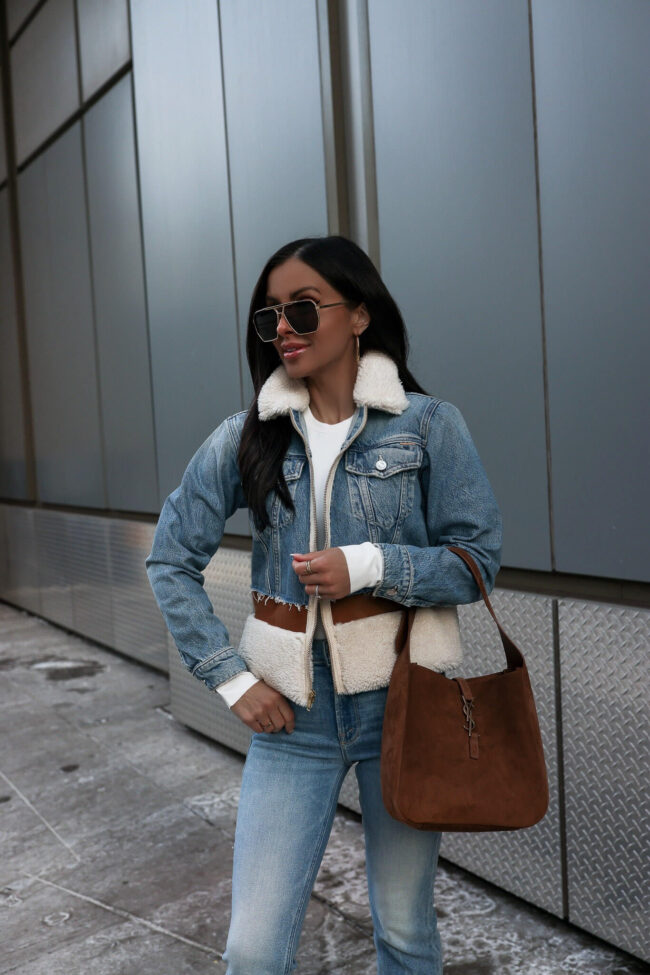 fashion blogger mia mia mine wearing a shearling denim jacket and a saint laurent suede hobo bag from saks