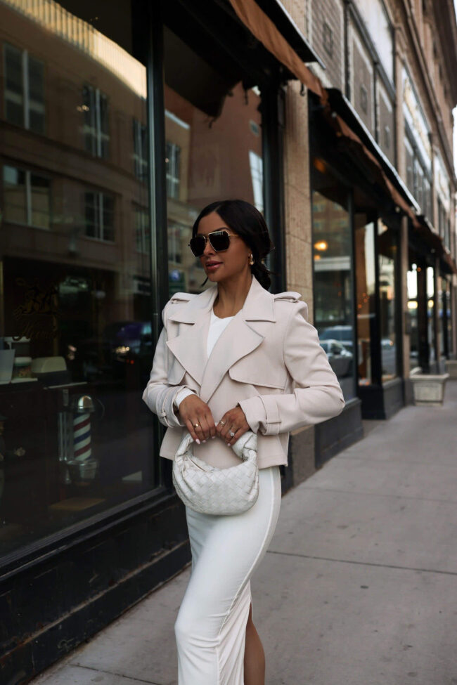 fashion blogger mia mia mine wearing a white dress and cropped trench for spring