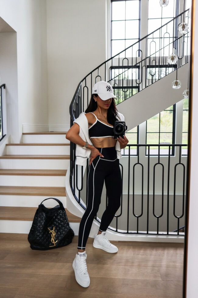 brunette fashion blogger wearing a black and white activewear set from amazon