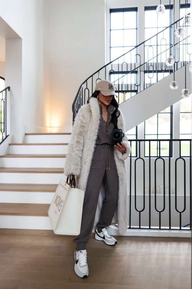 fashion blogger wearing a faux fur coat and casual jumpsuit for winter