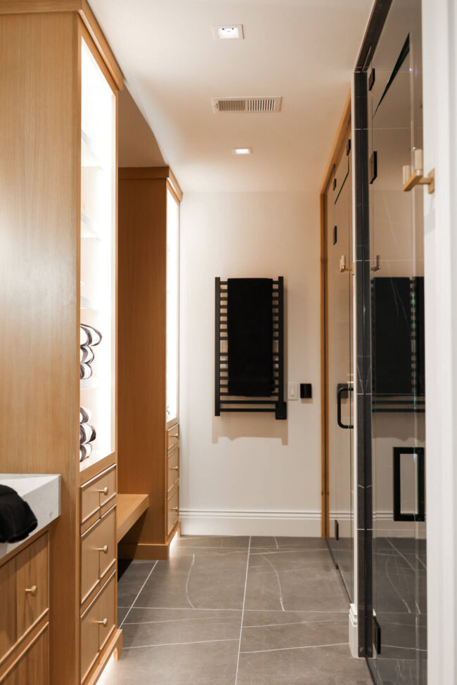 Home spa bathroom with glass sauna, white oak cabinetry and black heated towel rack