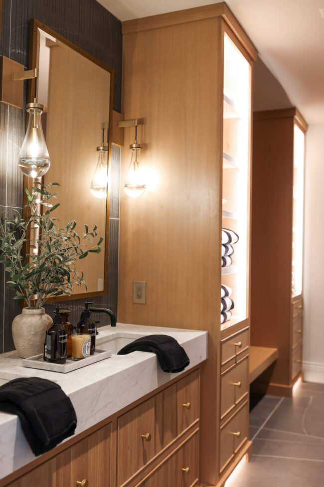Luxury spa bathroom with reeded white oak cabinetry, marble countertops and integrated shelving