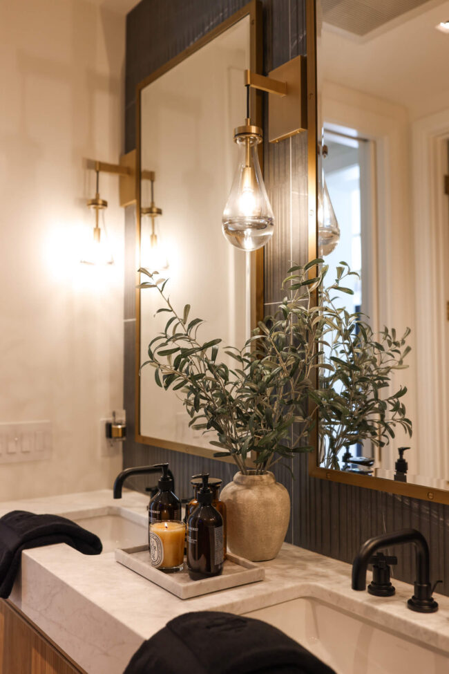 Luxury bathroom vanity with thick marble countertop, black faucets and raindrop pendant lights