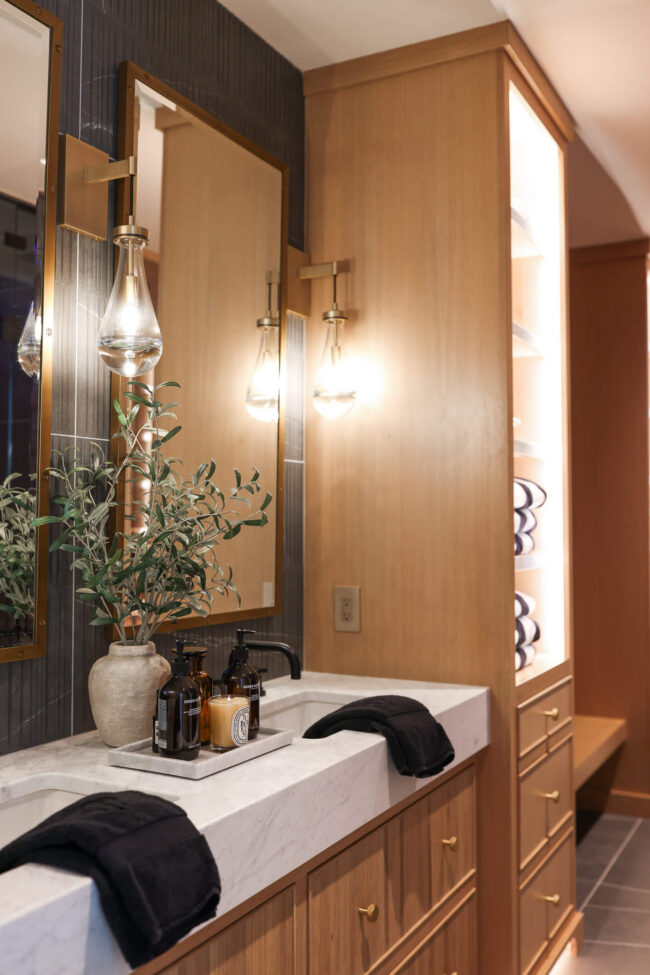 Reeded white oak bathroom vanity with thick marble countertop and brass hardware