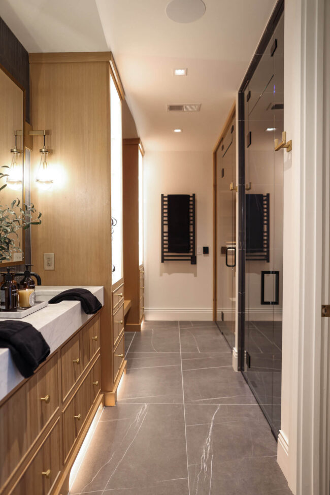 Luxury home spa bathroom with white oak cabinetry, steam shower and glass sauna