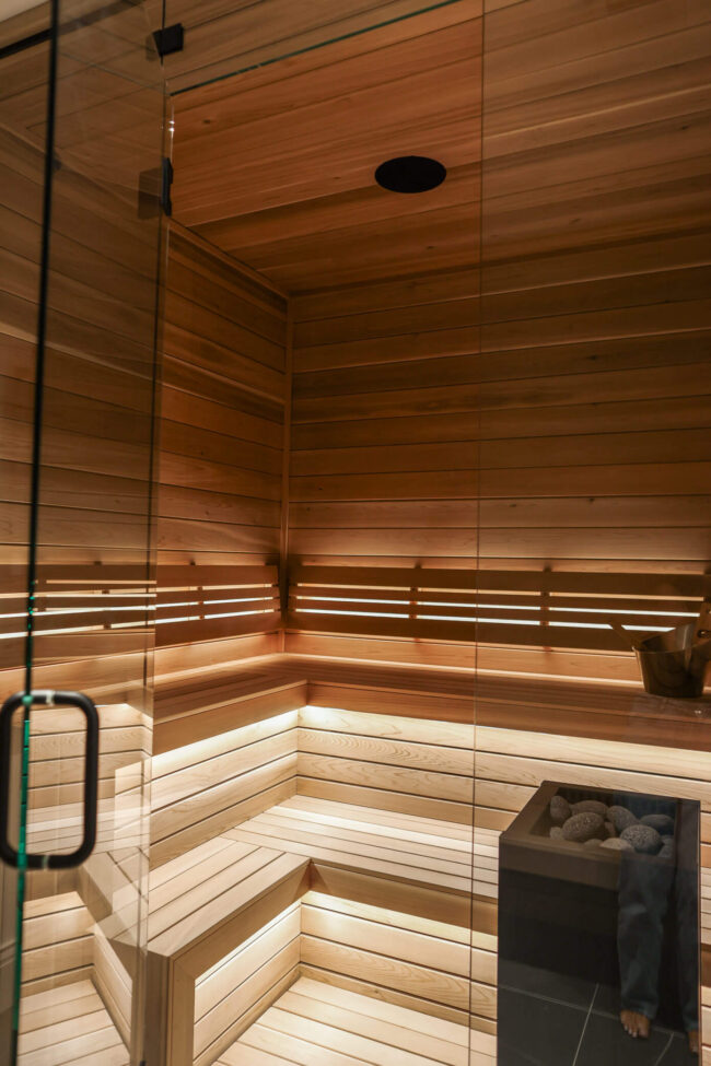 Luxury home sauna with wood benches and integrated LED lighting