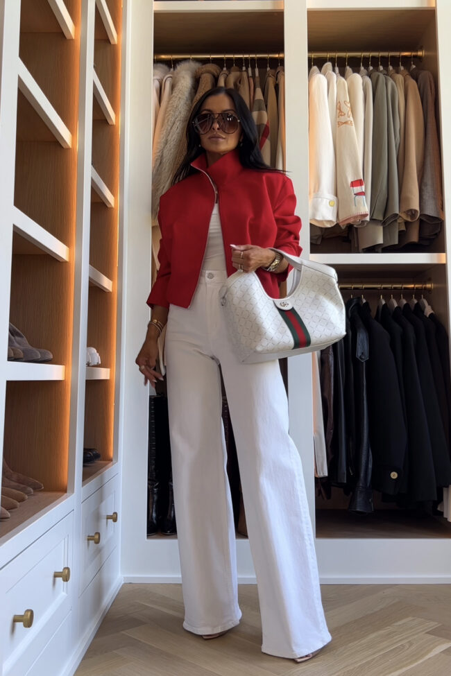 brunette fashion blogger wearing a red bomber jacket and white wide leg jeans from zara